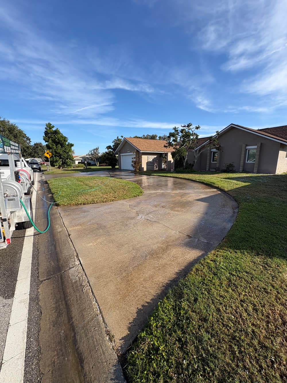 Dirty residential concrete driveway with heavy organic buildup before cleaning in Venice, Florida.